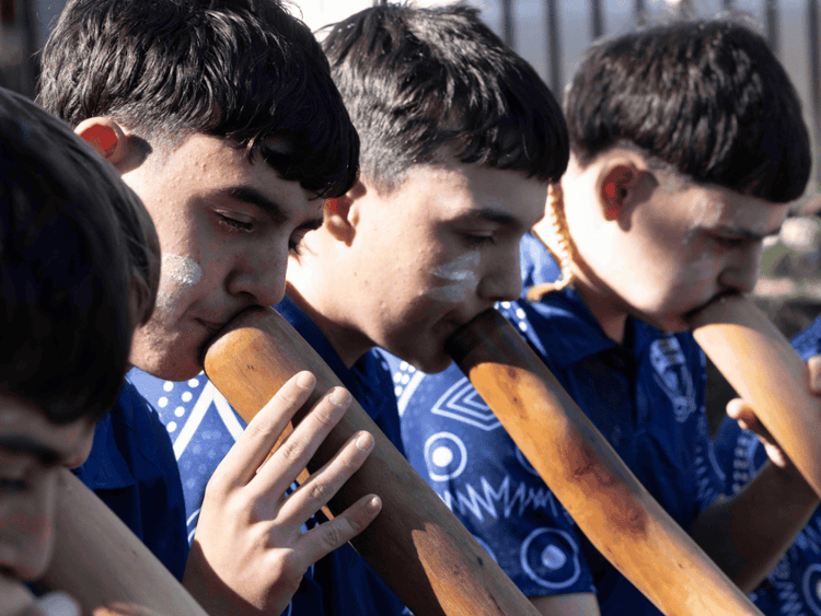 Four male Aboriginal students playing yidaki instruments
