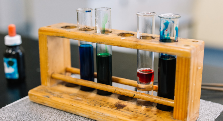 An image of test tubes in a wooden test tube holder