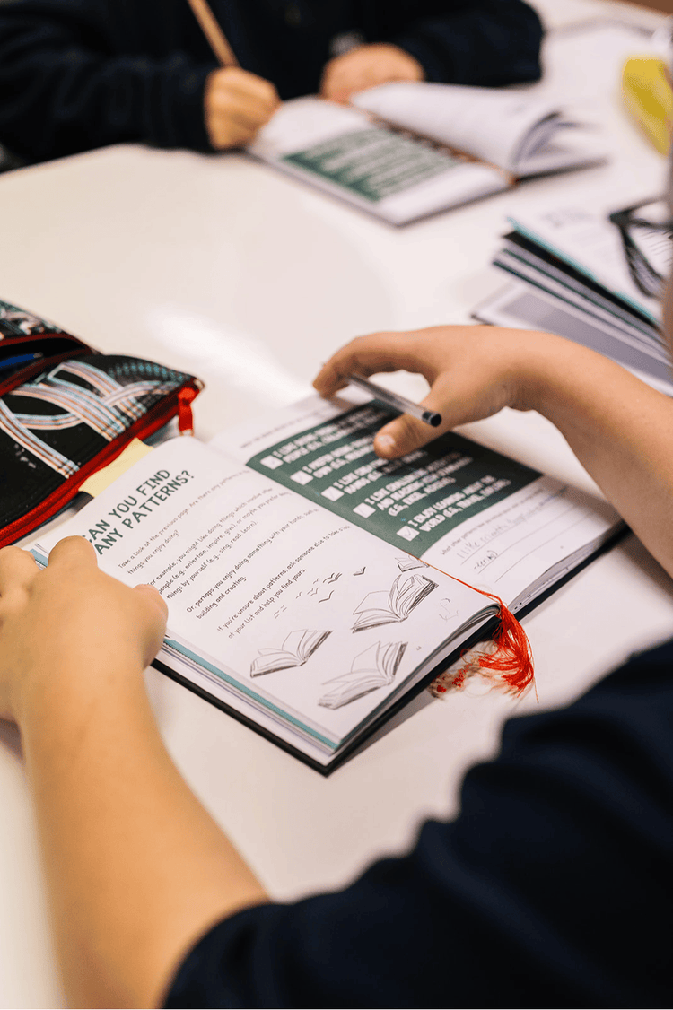 An image of two hands on a book about patterns
