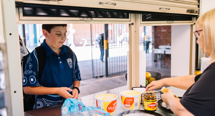 An image of a male student being served at the school canteen